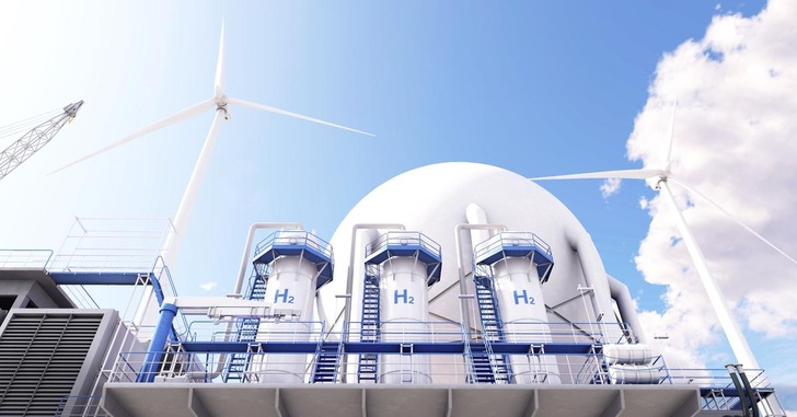 Wasserstoffproduktionsanlage mit H2-Tanks, Windturbinen und einer Kuppel unter einem blauen Himmel mit Wolken. - © Shutterstock