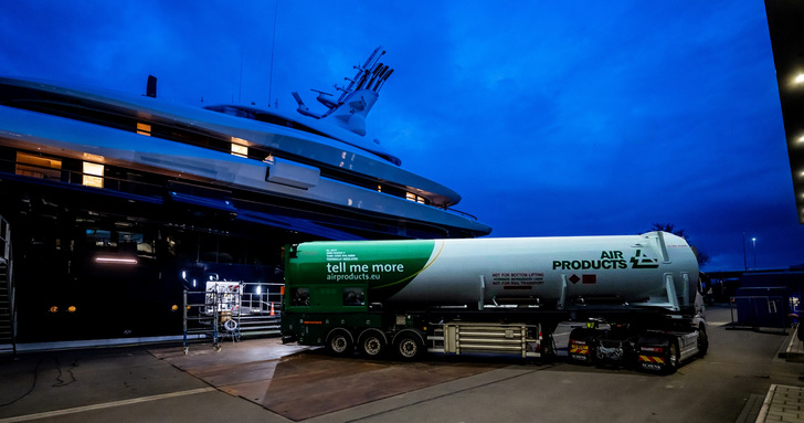 A large Air Products gas tanker parked beside a yacht at dusk, under a deep blue sky. - © Air Products