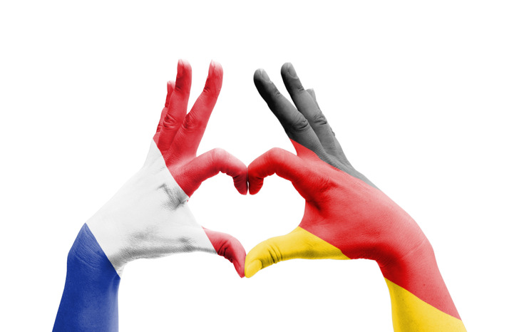 Two hands painted with French and German flags form a heart shape on a white background. - © SG- design - stock.adobe.com