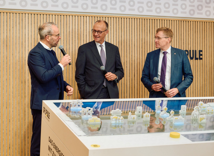 Ove Petersen (links), CEO und Mitgründer von GP Joule, zeigt Bundeskanzler Friedrich Merz und Schleswig-Holsteins Ministerpräsident Daniel Günther das „Energiesystem mit Zukunft“.
