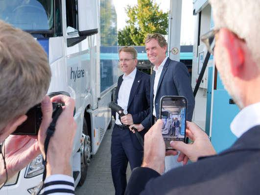 Schleswig-Holsteins Ministerpräsident Daniel Günther und Kiels Oberbürgermeister Ulf Kämpfer an 350-bar- und 700-bar-Zapfsäulen von Hy.Kiel. Sie stellen regional produzierten grünen Wasserstoff für Busse, Lkws und Pkws bereit.